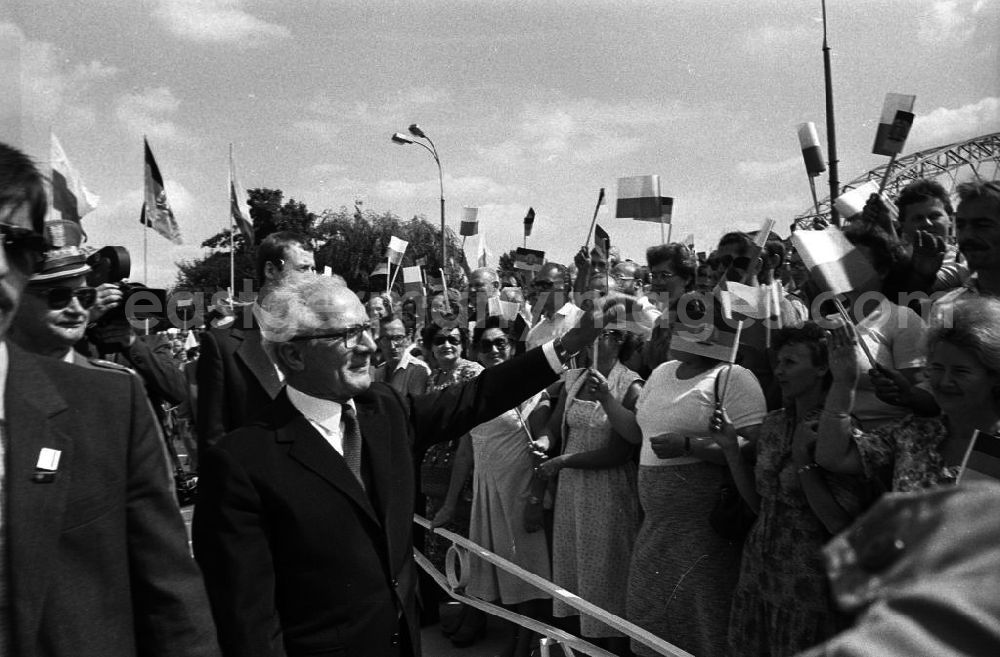 GDR photo archive: Warschau - Staatsbesuch von Erich Honecker, Staatsratsvorsitzenden der DDR, in der Volksrepublik Polen. Honecker winkt jubelnder Menschenmenge zu. Drumherum jubelnde Schaulustige / Zuschauer mit Fahnen / Fähnchen/ Flagge DDR und Polen in der Hand.