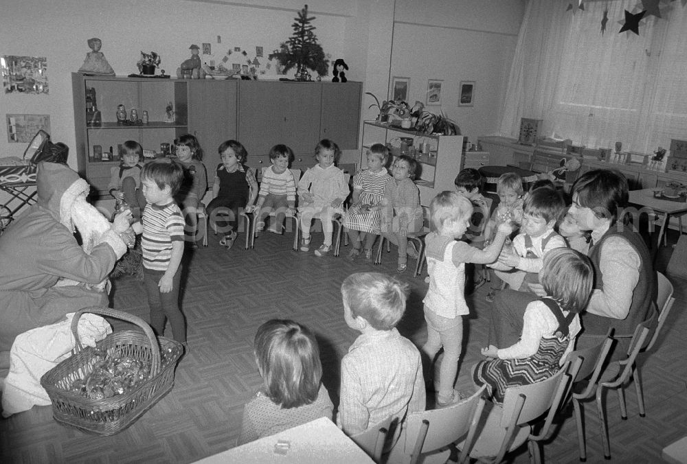 GDR picture archive: Berlin - The Santa Claus gives children with presents in a kindergarten in Berlin, the former capital of the GDR, German democratic republic
