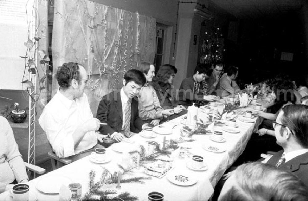 GDR photo archive: Berlin - Die Belegschaft im VEB Meßelektronik bei der Betriebs-Weihnachtsfeier. Mitarbeiter / Arbeiter sitzen zusammen an Tisch / Tafel.