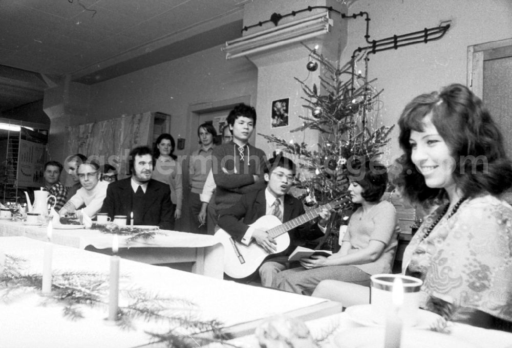 GDR image archive: Berlin - The staff at VEB Messelektronik MEB at the company Christmas party. A Vietnamese contract worker plays a guitar and sings in the Friedrichshain district of Berlin in the district Friedrichshain in Berlin, the former capital of the GDR, German Democratic Republic