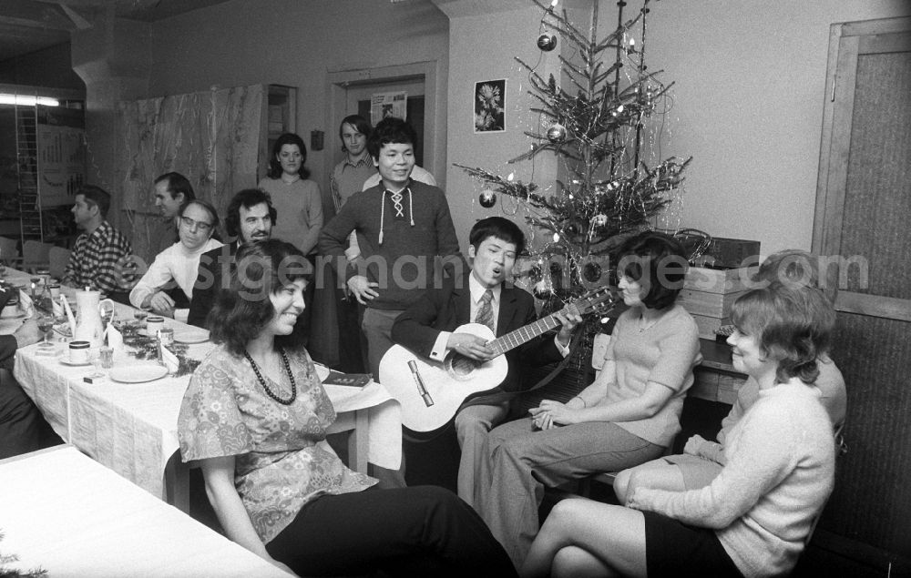 Berlin: The staff at VEB Messelektronik MEB at the company Christmas party. A Vietnamese contract worker plays a guitar and sings in the Friedrichshain district of Berlin in the district Friedrichshain in Berlin, the former capital of the GDR, German Democratic Republic