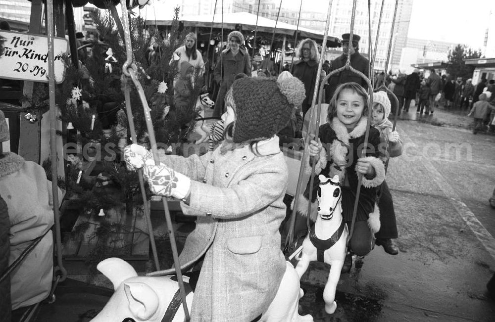 GDR image archive: Berlin - Kinder bei einer Fahrt mit dem Karussell auf dem Weihnachtsmarkt am Alexanderplatz in Berlin-Mitte. Eine Fahrt kostet 2