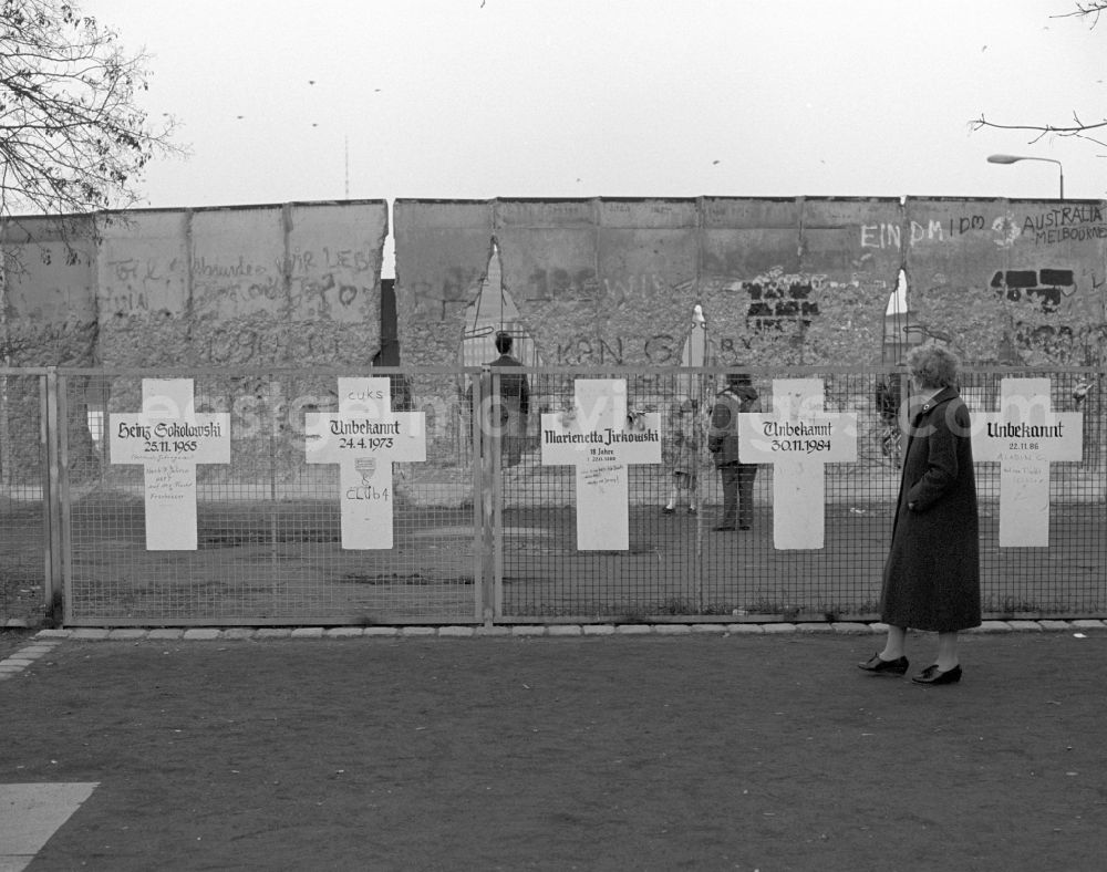 GDR photo archive: Berlin - White crosses on a fence in front of the Berlin Wall in Berlin. Each white cross represents a person who died while trying to escape from East Germany