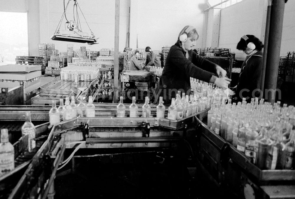 GDR photo archive: Berlin - Valuable material separation in the combine VEB secondary raw material capture (SERO) in Berlin, the former capital of the GDR, German democratic republic. Employees sort here old glass bottles about a conveyor belt run. After the turn the Alba daughter Abfallwirtschaftsunion (AWU) took over the company in meal village