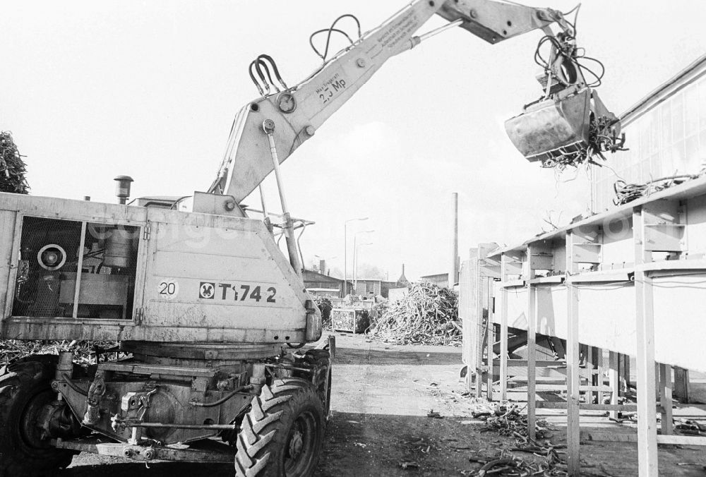 GDR picture archive: Berlin - Valuable material separation in the combine VEB secondary raw material capture (SERO) in Berlin, the former capital of the GDR, German democratic republic. An employee separates to begin with valuable metals with the help of one excavators. After the turn the Alba daughter Abfallwirtschaftsunion (AWU) took over the company in Mahlsdorf