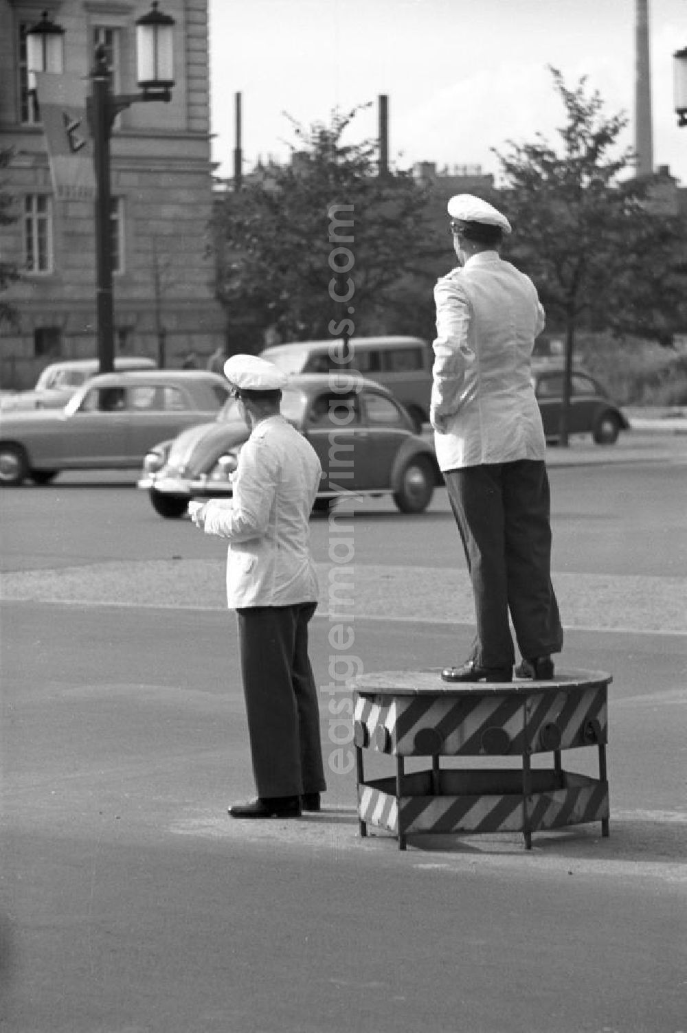 GDR photo archive: Berlin - Verkehrspolizisten regeln auf der Straße des 17. Juni in Westberlin den Verkehr. Im Hintergrund Werbung für die Interbau, die Internationale Bauausstellung 1957. In den 5