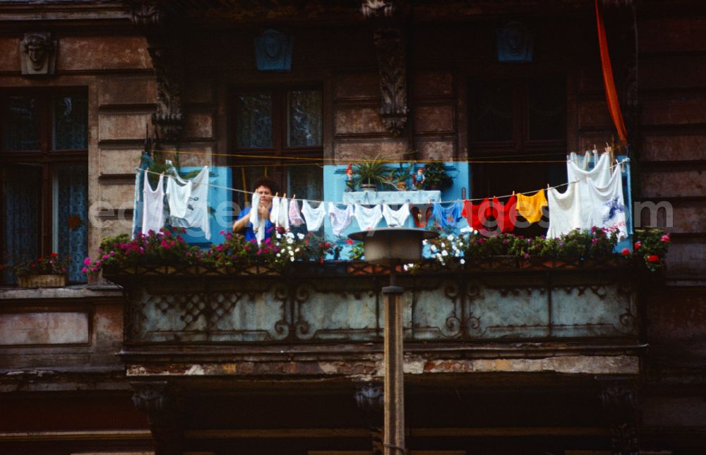 GDR photo archive: Berlin - Woman hangs up her freshly washed laundry on the balcony in Berlin on the territory of the former GDR, German Democratic Republic