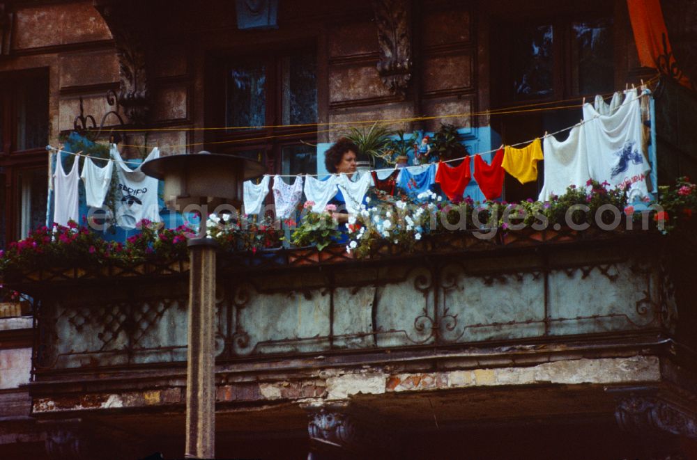GDR picture archive: Berlin - Woman hangs up her freshly washed laundry on the balcony in Berlin on the territory of the former GDR, German Democratic Republic