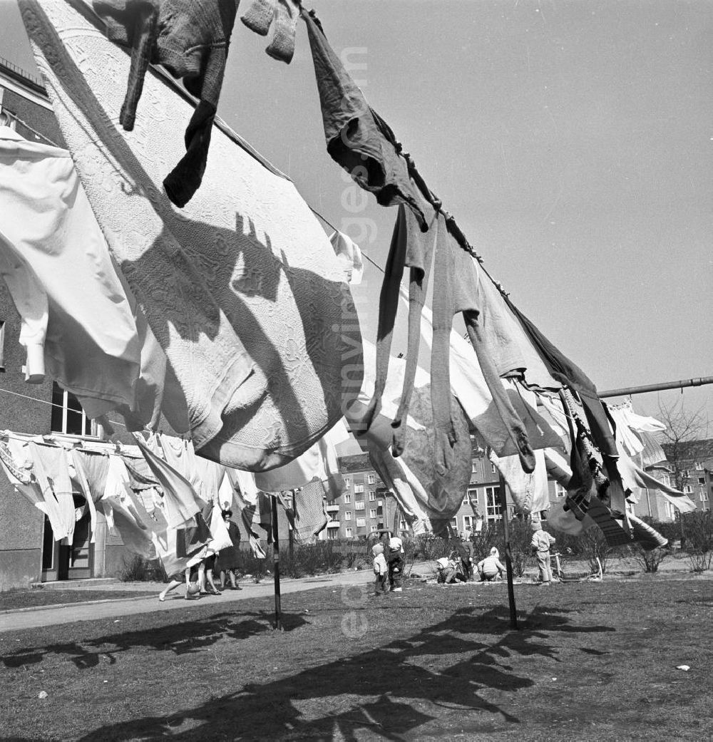 GDR picture archive: Berlin - Hauswäsche / Wäsche der Mieter hängt auf der Wäscheleine / Leine vor Neubauten, im Hintergrund spielen Kinder.
