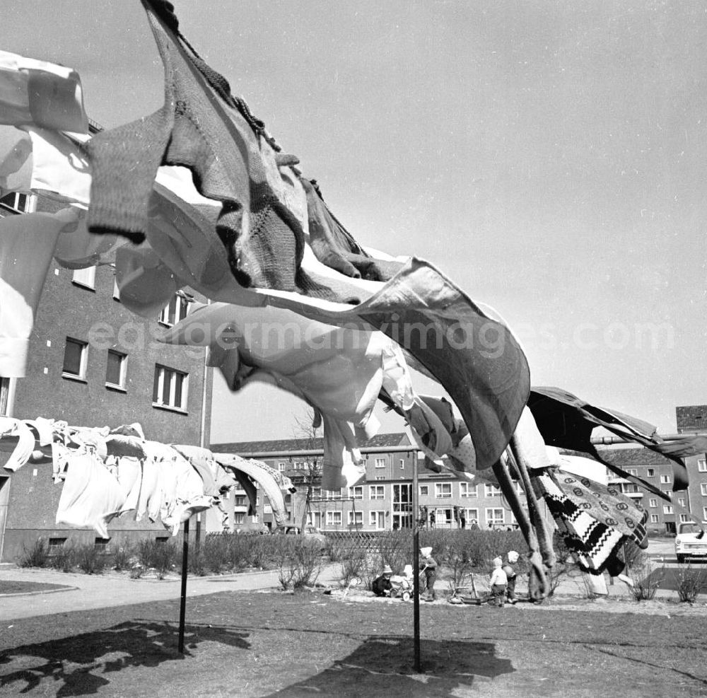 GDR image archive: Berlin - Hauswäsche / Wäsche der Mieter hängt auf der Wäscheleine / Leine vor Neubauten, im Hintergrund spielen Kinder.