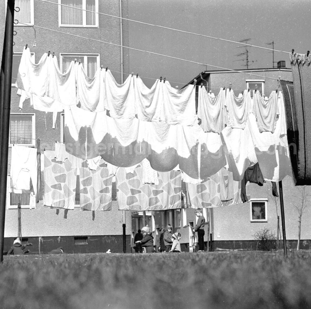 GDR photo archive: Berlin - Hauswäsche / Wäsche der Mieter hängt auf der Wäscheleine / Leine vor Neubauten, im Hintergrund spielen Kinder.