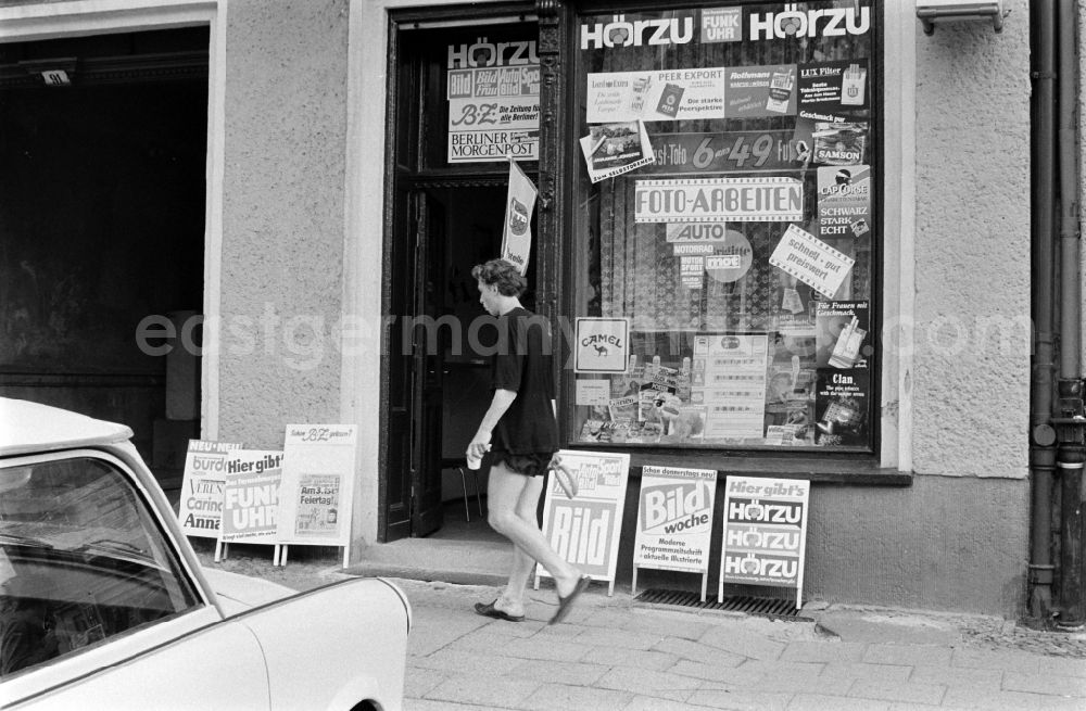 GDR photo archive: Berlin - Exhibitors in front of a newsstand at the Karl-Marx-Allee in Berlin - Friedrichshain advertise for newspapers and magazines like Bild, Bild-Woche, Hoerzu, Funkuhr, Burda, BZ and Berliner Morgenpost 