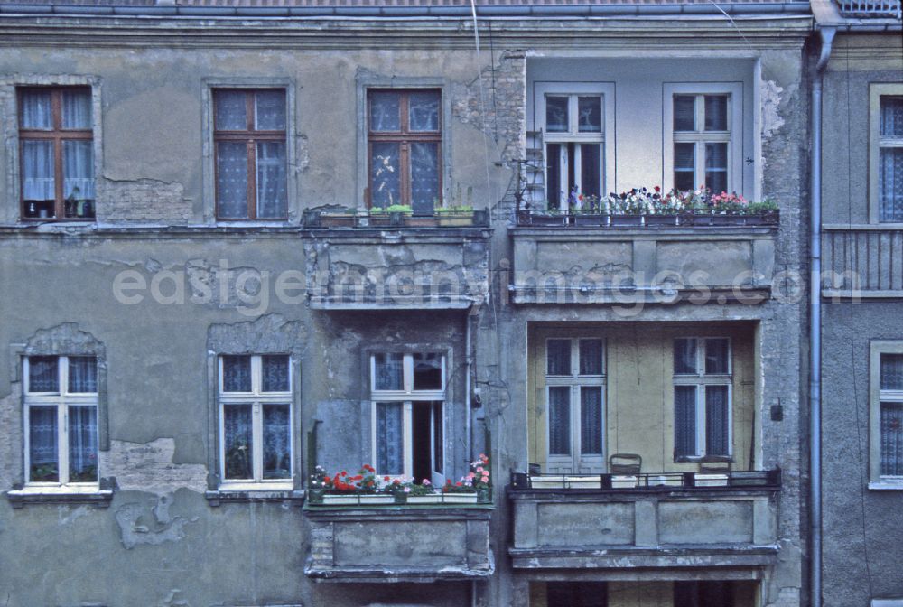 Berlin: Old building facade and building front with balconies in need of renovation on street Weserstrasse in the district Friedrichshain in Berlin Eastberlin on the territory of the former GDR, German Democratic Republic