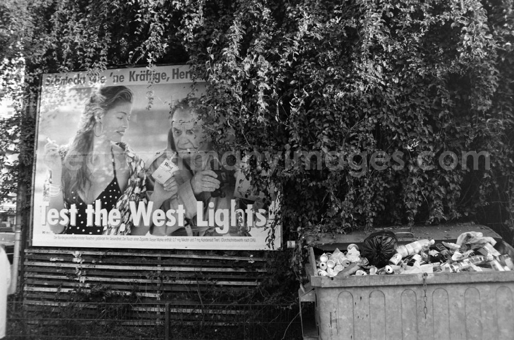 GDR picture archive: Berlin - Cigarette advertisement for West light next to a full garbage can in West Berlin