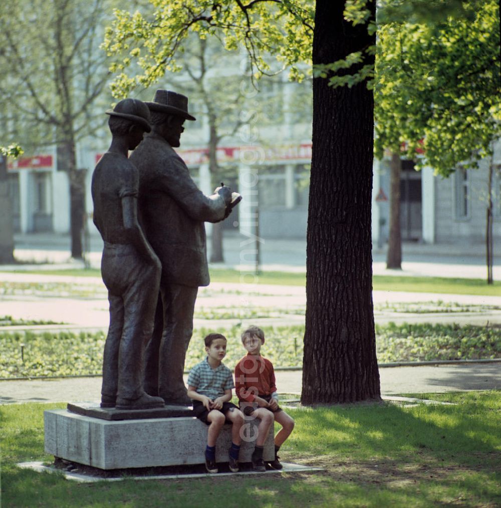 GDR image archive: Berlin - Zwei Jungs sitzen auf dem Podest des Denkmals für den bekannten Berliner Zeichner und Grafiker Heinrich Zille, der vor allem für seine Darstellungen des Berliner Milljöhs der 20er Jahre bekannt geworden ist. Das von dem Bildhauer Heinrich Drake geschaffene Bronzestandbild hatte seit Mitte der 6