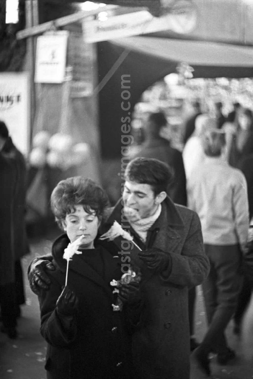 GDR picture archive: Berlin - Ein junges Paar ißt Zuckerwatte auf dem Berliner Weihnachtsmarkt.