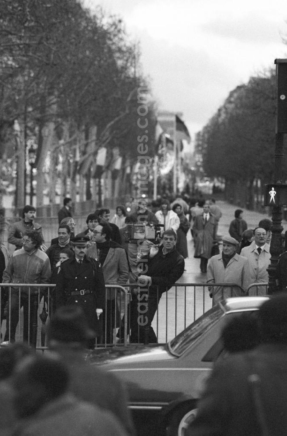 GDR picture archive: Paris - Zuschauer an der Absperrung der beflaggten Champs Elysees anläßlich des Staatsbesuchs von Erich Honecker, Vorsitzender des Staatsrates DDR, in Paris.