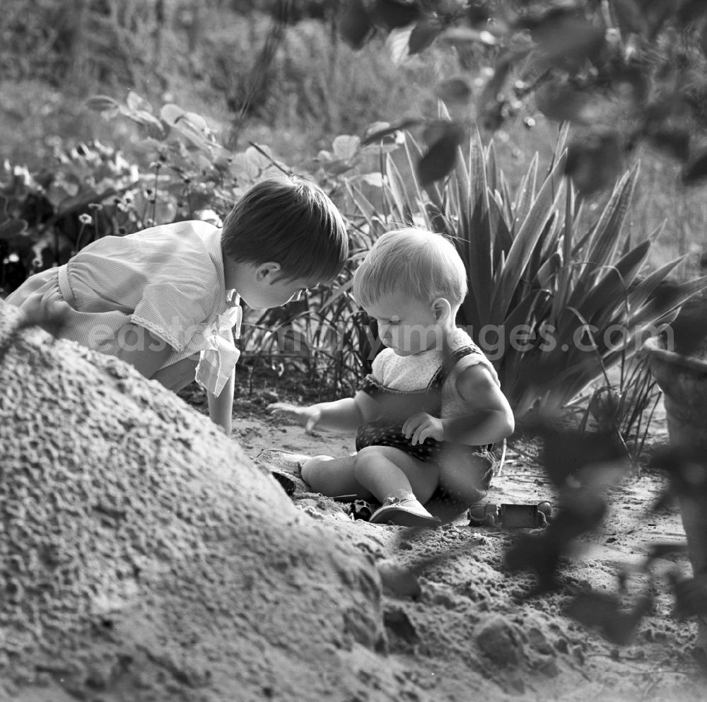 GDR photo archive: Warnemünde - Two children playing in the sand in Warnemünde in Mecklenburg - Western Pomerania