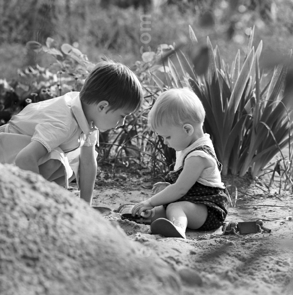GDR image archive: Warnemünde - Two children playing in the sand in Warnemünde in Mecklenburg - Western Pomerania