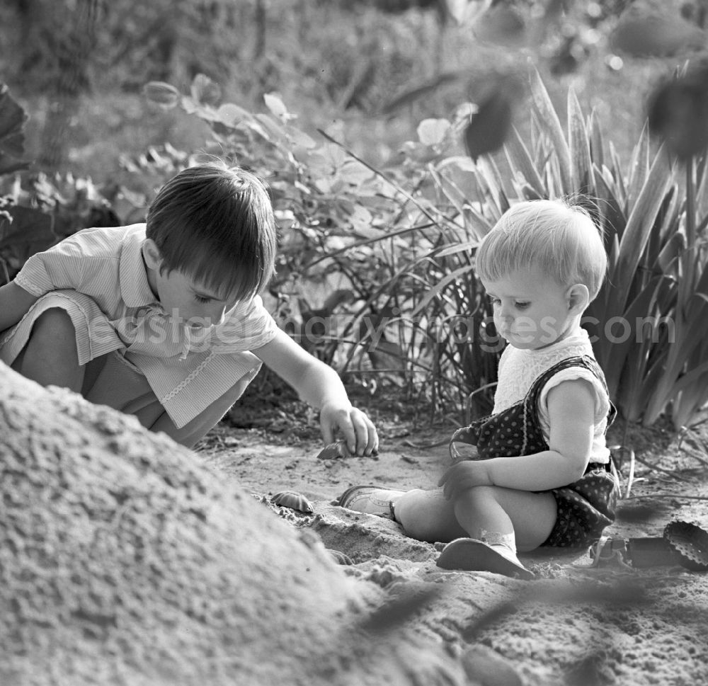 GDR photo archive: Warnemünde - Two children playing in the sand in Warnemünde in Mecklenburg - Western Pomerania