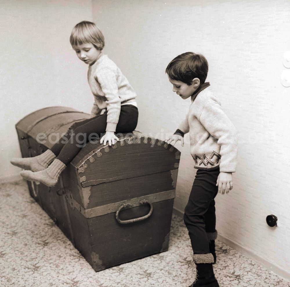 GDR image archive: Berlin - Two children sit on a big old wooden chest / wooden box in Berlin, the former capital of the GDR, German democratic republic