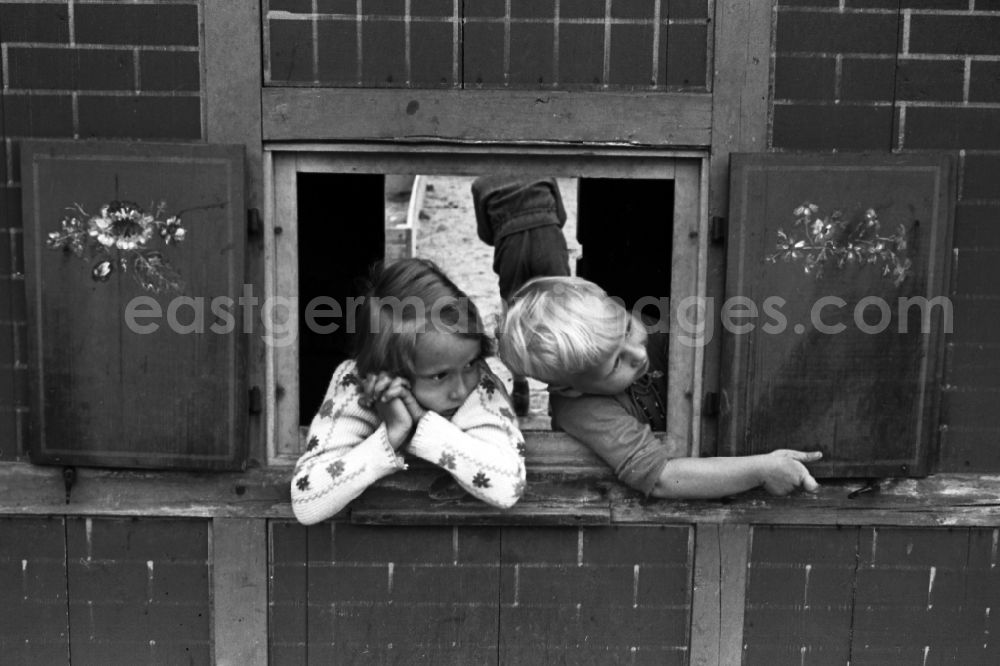 GDR picture archive: Bad Dürrenberg - Two children play in a play house with shutters on a playground in bath drought mountain in the federal state Saxony-Anhalt in Germany