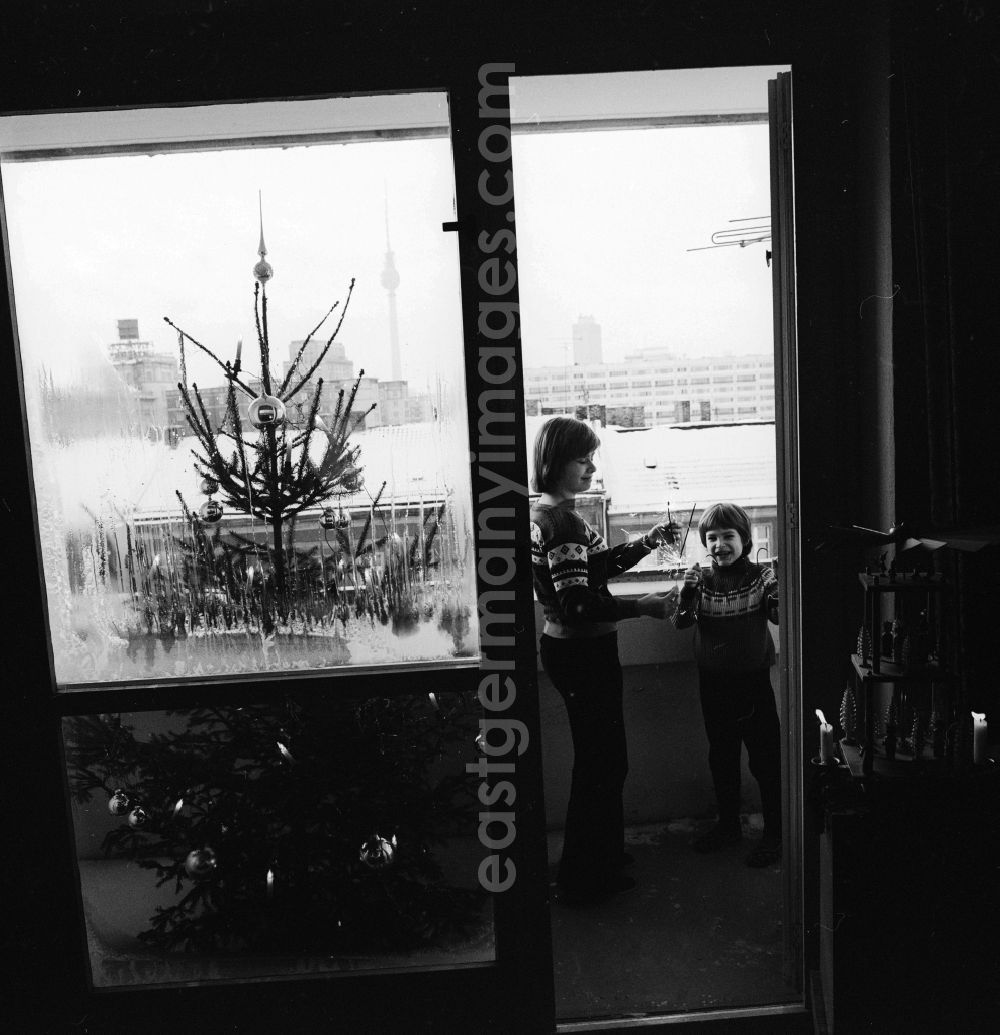 GDR picture archive: Berlin - Two children stand with sparklers on a balcony in Berlin. In addition, a decorated Christmas tree