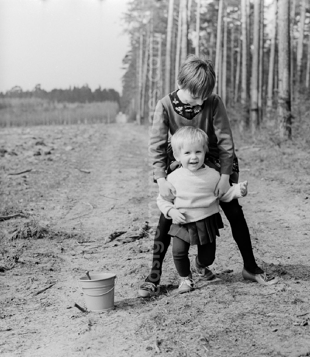 Wernigerode: Two small children with a bucket and a shovel play in the sand in Wernigerode in the federal state Saxony-Anhalt on the territory of the former GDR, German Democratic Republic