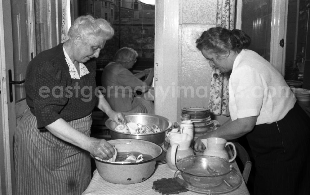 GDR picture archive: Leuna - Two older ladies wash in enamel bowls dishes from in Leuna in the federal state Saxony-Anhalt in Germany