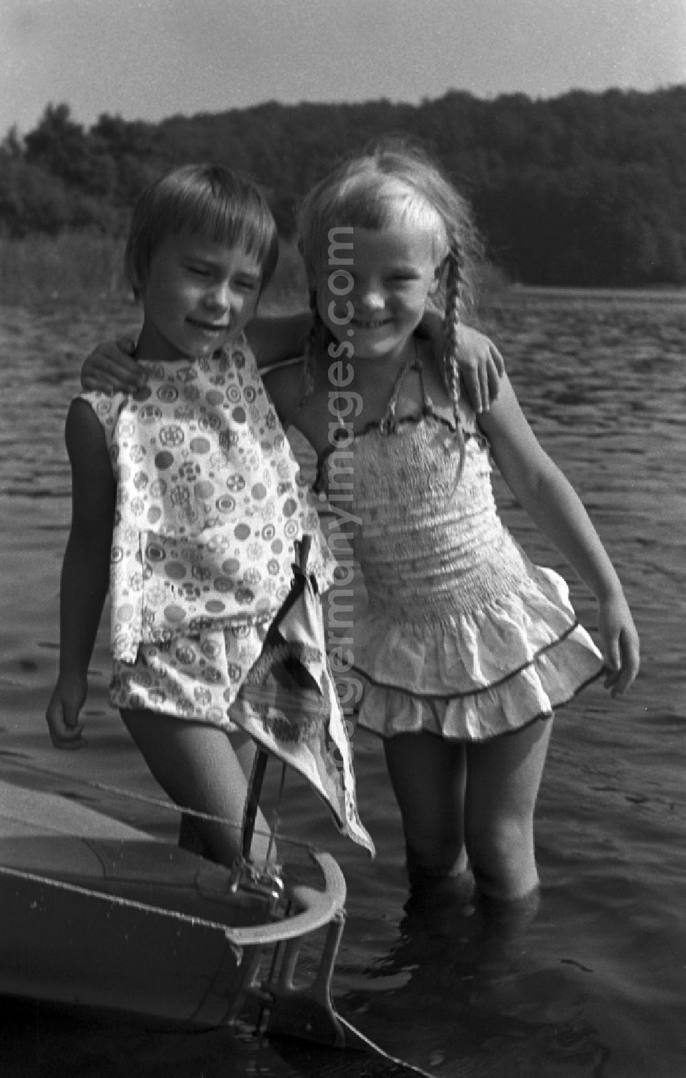 Neuruppin OT Stendenitz: Two girls standing in water in Brandenburg. Family camping holidays at Rottstielfließ on Tornowsee in Brandenburg