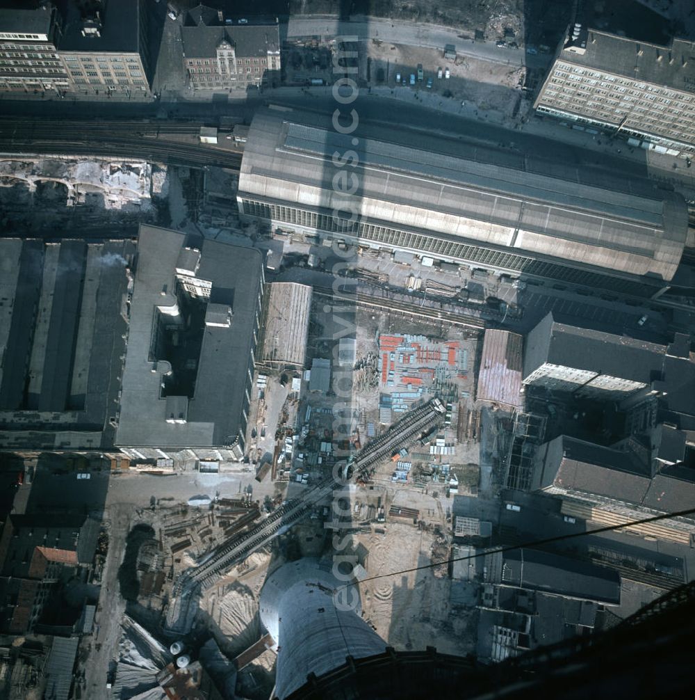 Vertical aerial photograph Berlin - Senkrechter Blick von dem im Bau befindlichen Fernsehturm auf die Gebäude am Fuß des Turms, den Bahnhof Alexanderplatz (o.) und das Berolinahaus (o.r.).