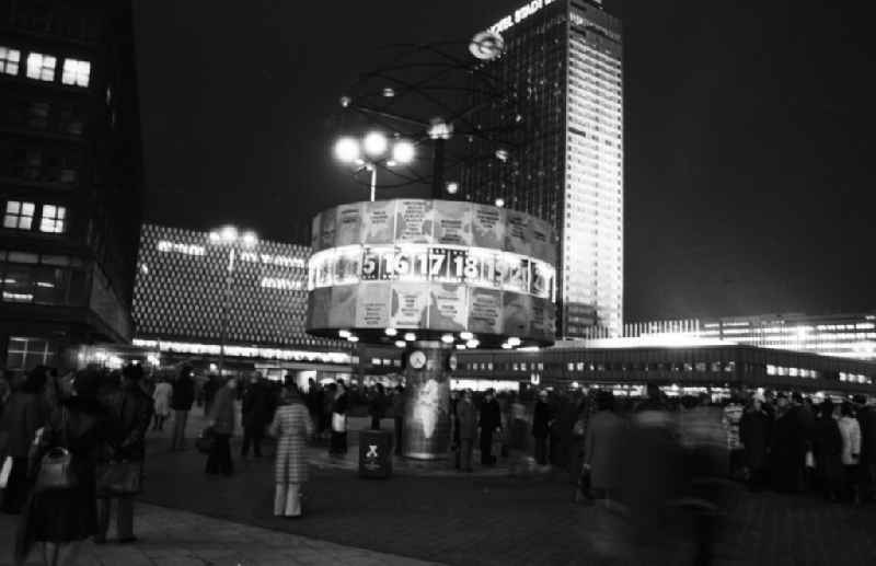 Nachtaufnahme: Blick auf die nächtliche Stimmung an der Weltzeituhr am Alexanderplatz in Berlin-Mitte, im Hintergrund das Centrum Warenhaus und das Hotel Stadt Berlin.