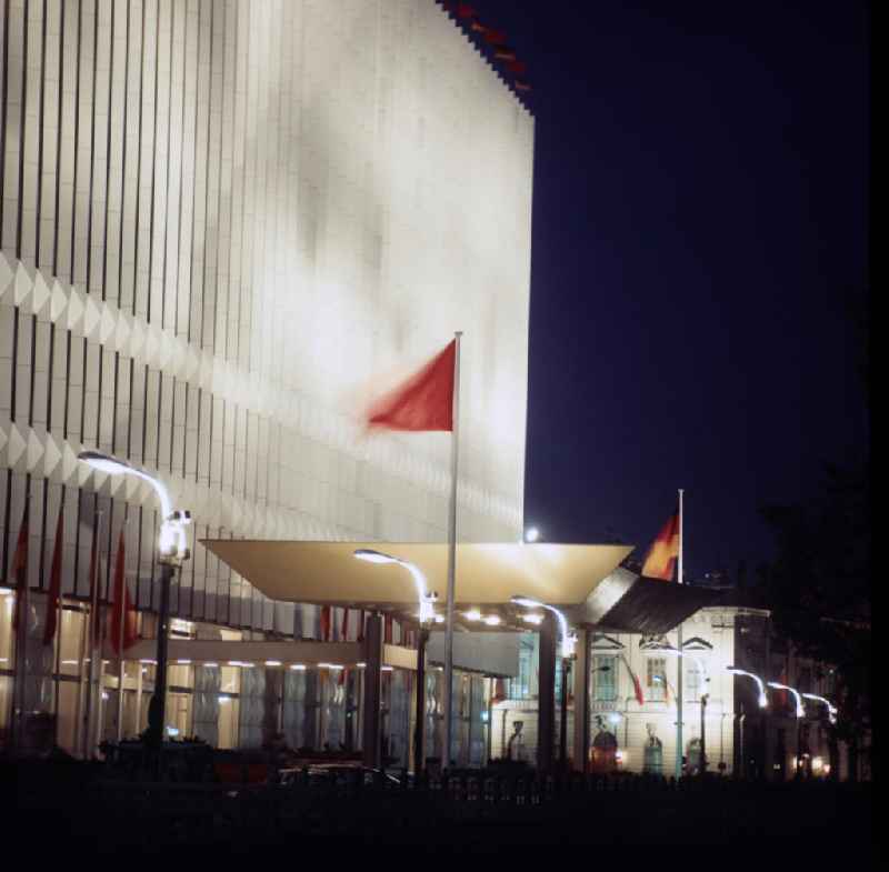 Nachtaufnahme: Blick auf die beleuchtete Fassade und den beflaggten Eingang des Ministeriums für Auswärtige Angelegenheiten (MfAA) Unter den Linden in Berlin-Mitte. Das Mitte der 6