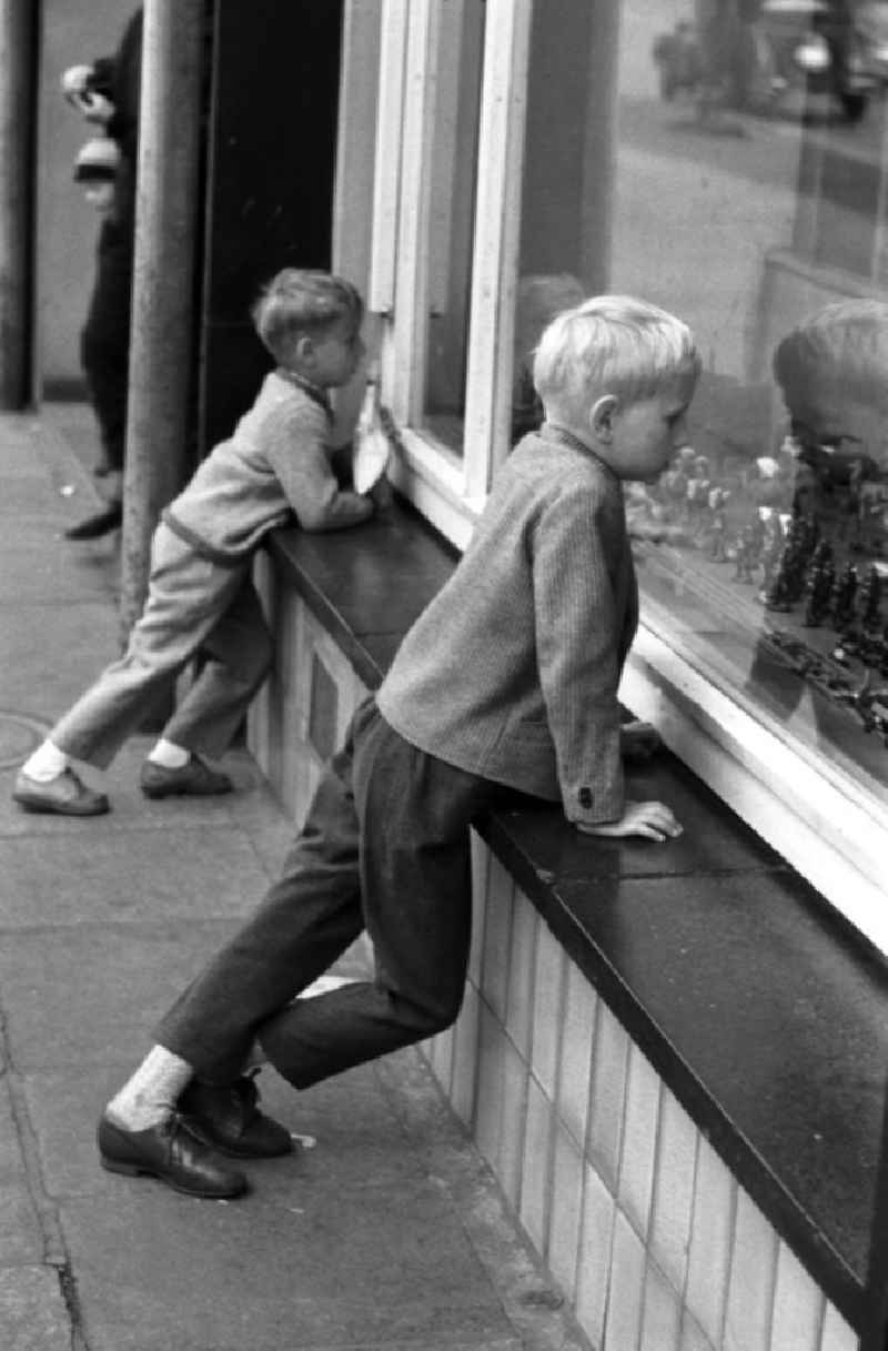 Dresden 12.6.1962 Zwei Jungs schauen neugierig durch das Schaufenster eines Dresdner Spielwarengeschäftes auf die ausgestellten Spielfiguren.