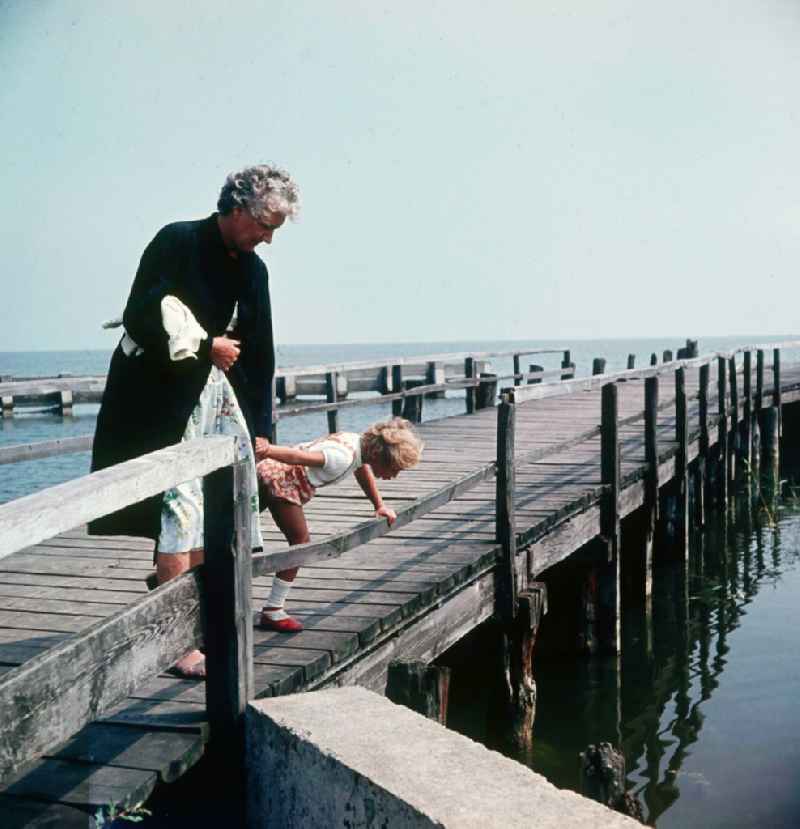 A granny is with her grandchild on the summer vacation on the Baltic Sea in Ahrenshoop in the federal state Mecklenburg-West Pomerania in the area of the former GDR, German democratic republic