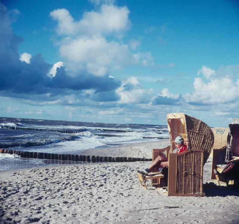 Vacationer in a beach basket on the beach on the Baltic Sea in Ahrenshoop in the federal state Mecklenburg-West Pomerania in the area of the former GDR, German democratic republic