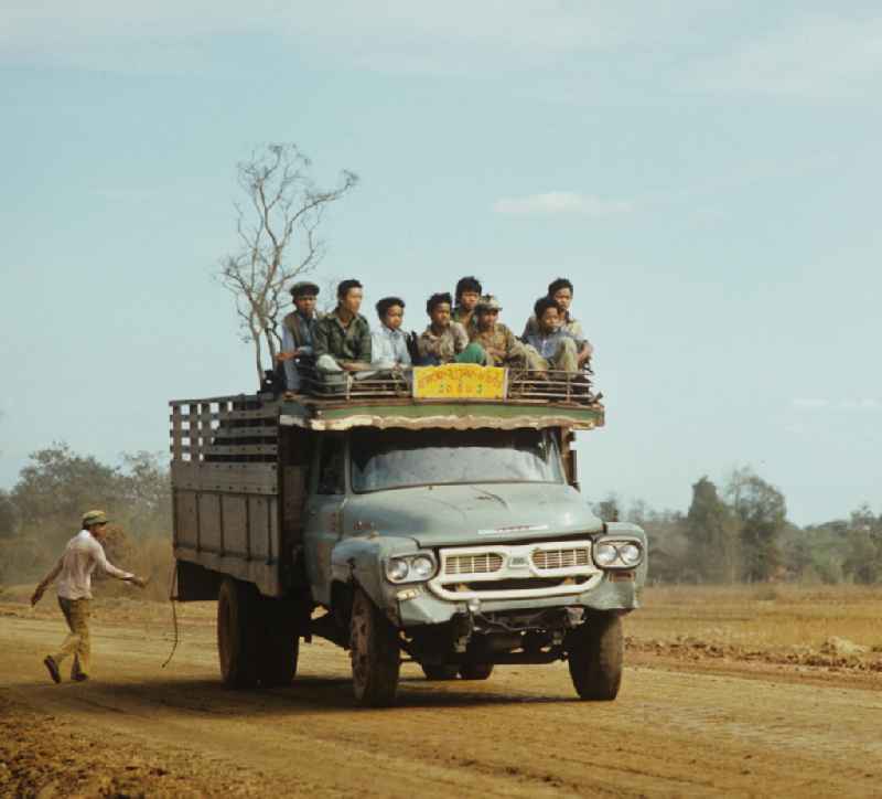 Mit Waren und Menschen vollbeladener Transporter auf einer Straße in der Demokratischen Volksrepublik Laos.