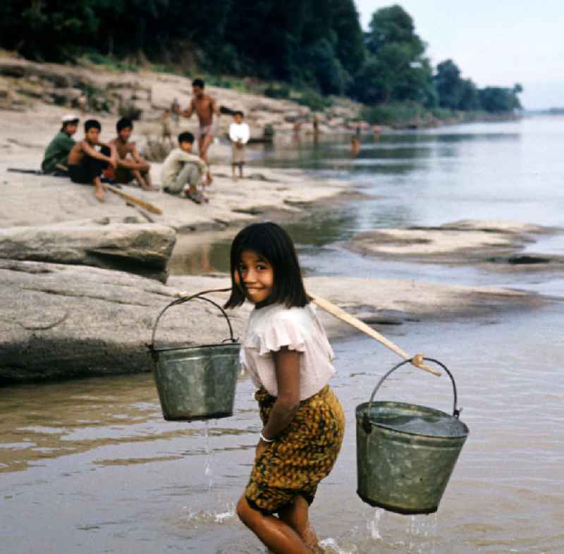 Mädchen holt mit Eimern Wasser im Fluß Mekong in der Demokratischen Volksrepublik Laos.