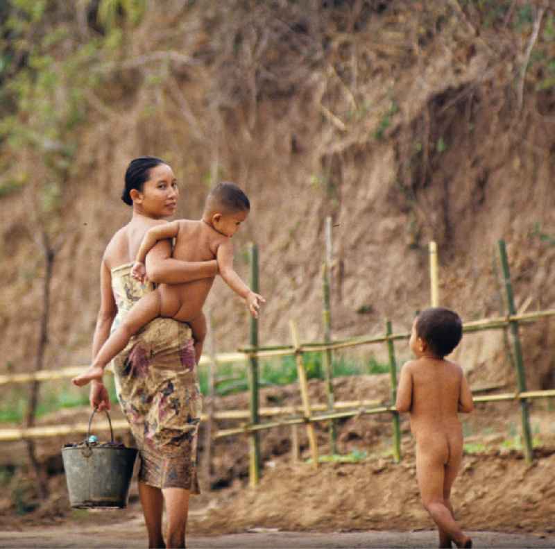 Frau mit Kindern am Ufer des Flusses Mekong in der Demokratischen Volksrepublik Laos.