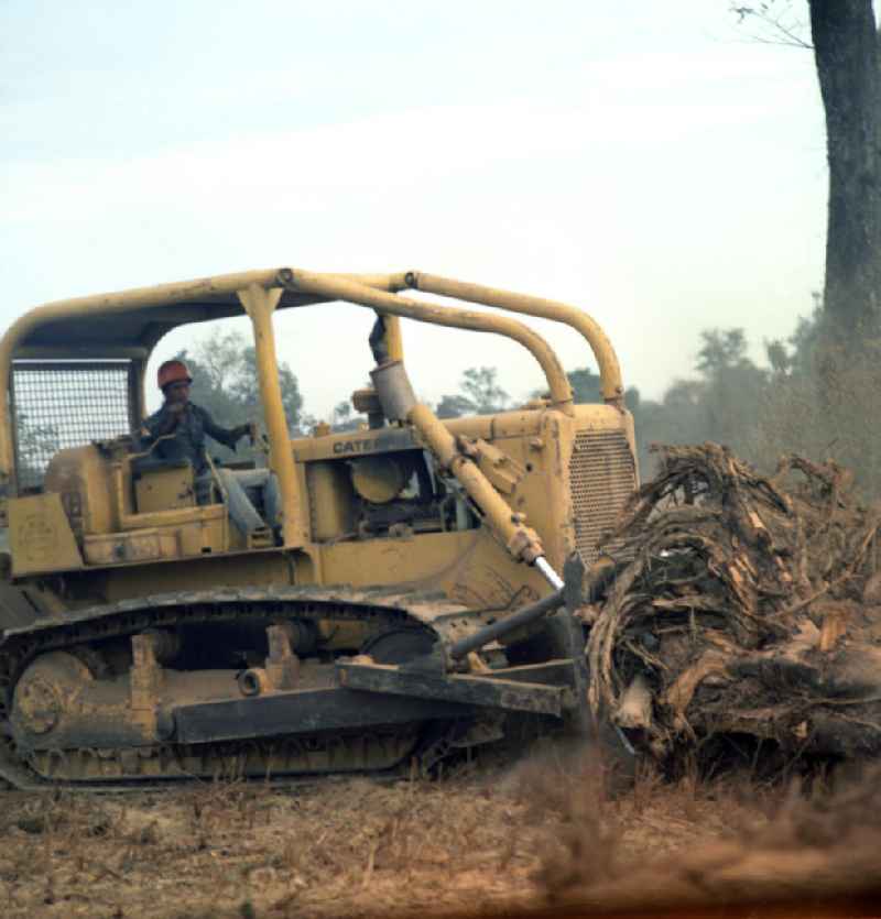 Einsatz von US-amerikanischen Baumaschinen, hier eine Planierraupe der US-amerikanischen Firma Caterpillar, für den Straßenbau in der Demokratischen Volksrepublik Laos.