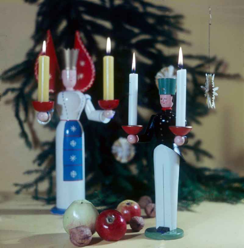Stilted Christmassy craft art from the Erzgebirge in Anna's mountain book wood in the federal state Saxony in the area of the former GDR, German democratic republic. Here a miner and an angel with candles