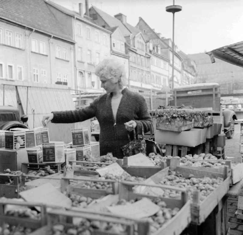 A woman buys bulb at the weekly market in Arnstadt in the federal state Thuringia in the area of the former GDR, German democratic republic