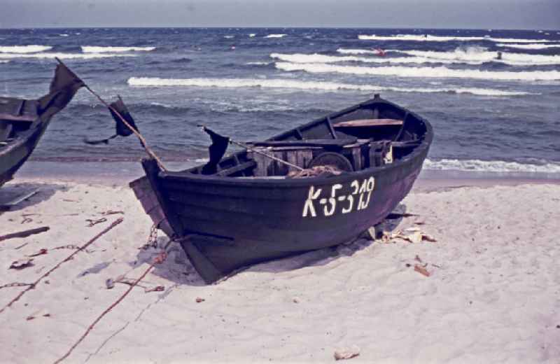 Sandy beach of the Baltic Sea with wooden fishing boat on street Duenenweg in Baabe, Mecklenburg-Western Pomerania on the territory of the former GDR, German Democratic Republic