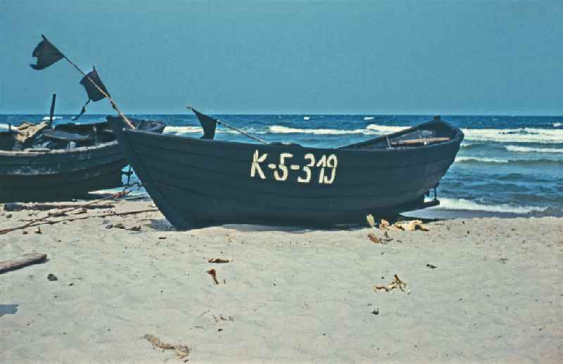 Sandy beach of the Baltic Sea with wooden fishing boat on street Duenenweg in Baabe, Mecklenburg-Western Pomerania on the territory of the former GDR, German Democratic Republic