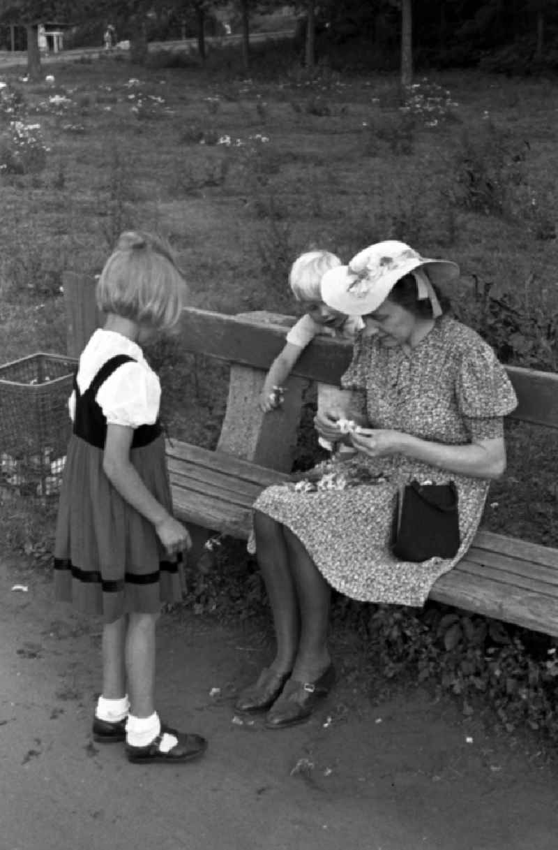 Woman with care and two children on a park-bench in bath Drought mountain in the federal state Saxony-Anhalt in Germany