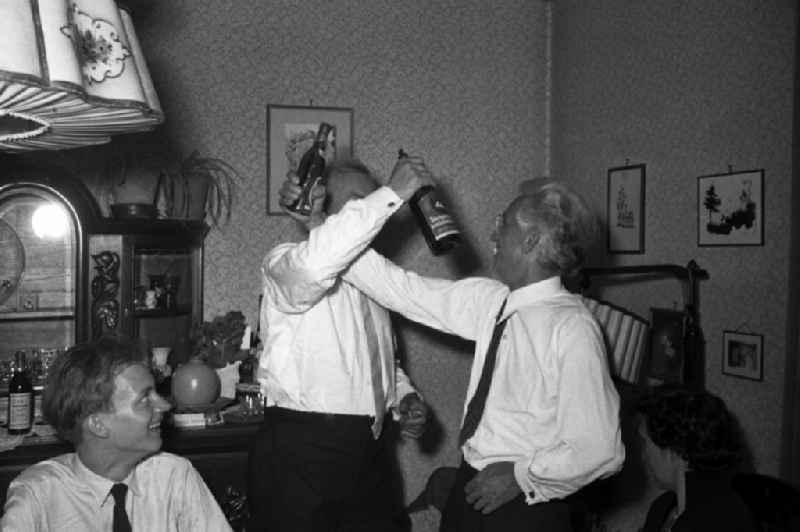 Two older men drink 'brotherhood' at a family celebration in bath Lauchstaedt in the federal state Saxony-Anhalt to the area of the former GDR, German democratic republic