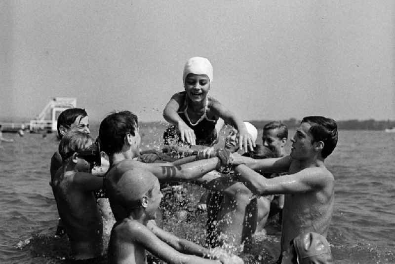 Kinder in Badbekleidung zum Teil mit Badekappe haben Spaß beim Baden im Scharmützelsee / See im Ferienlager  'Feliks Dzierzynski' Bad Saarow. In der DDR gab es vor allem in den Sommerferien Betriebsferienlager, die hauptsächlich von Großbetrieben für Kinder der Beschäftigten unterhalten wurden. Außerdem gab es Pionierflager, die über die Schulen in Zusammenarbeit mit der Pionierorganisation und der FDJ organisiert wurden.