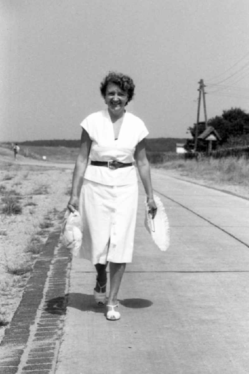 A woman strolls on the seafront in Bansin in the federal state Mecklenburg-West Pomerania in the area of the former GDR, German democratic republic