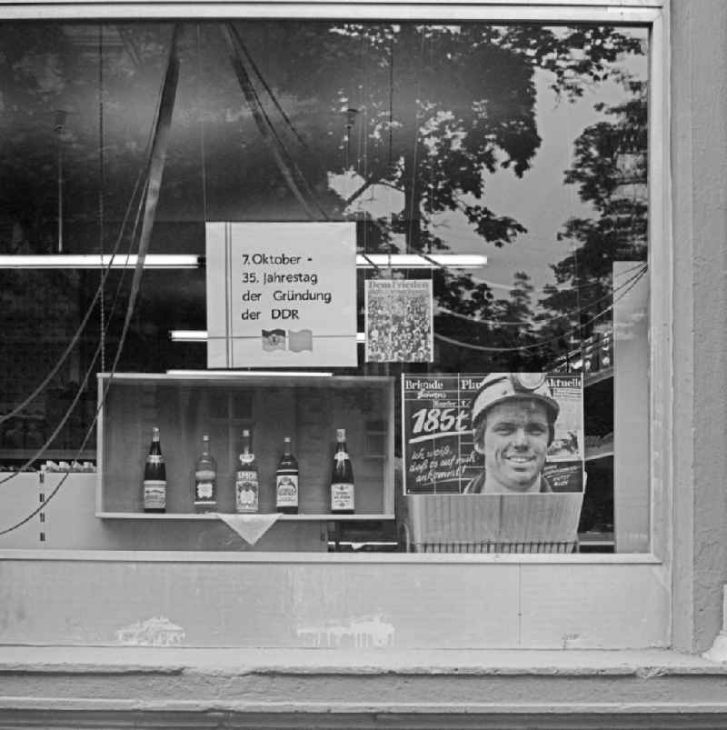 Ideologically oriented slogan and lettering on poster advertising in a shop window for alcohol and spirits in Bautzen in GDR