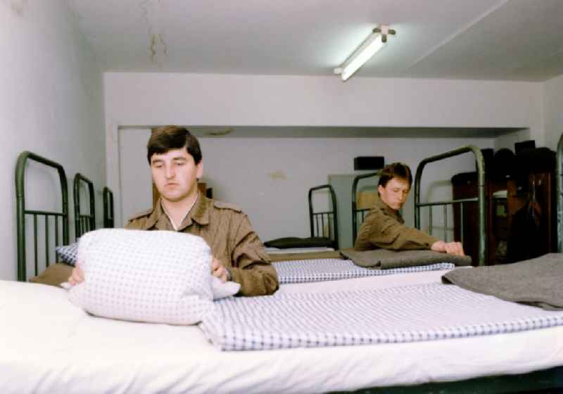 Young soldier when making the bed in an accommodation space of the NVA regiment, Friedrich Wolf 'in Beelitz in present-day state of Brandenburg